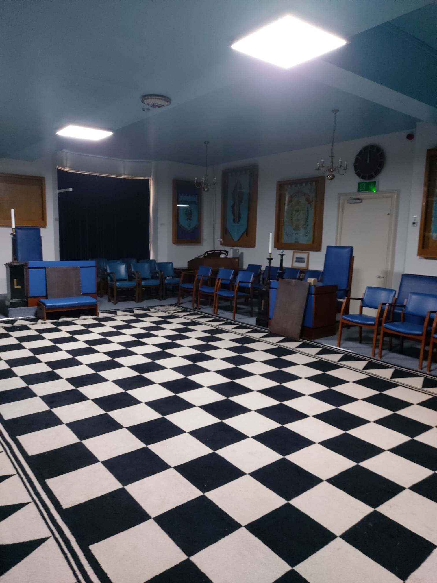 A Picture of the Coventry Lodge Room with black and white floor, showing the Master's chair and the junior Warden's chair